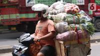 Warga membawa bahan makanan dengan sepeda motor saat melintas di kawasan Tangerang, Banten, Rabu (16/2/2022).Bank Indonesia (BI) memperkirakan terjadi penurunan harga komoditas atau deflasi pada Februari 2022. (Liputan6.com/Angga Yuniar)