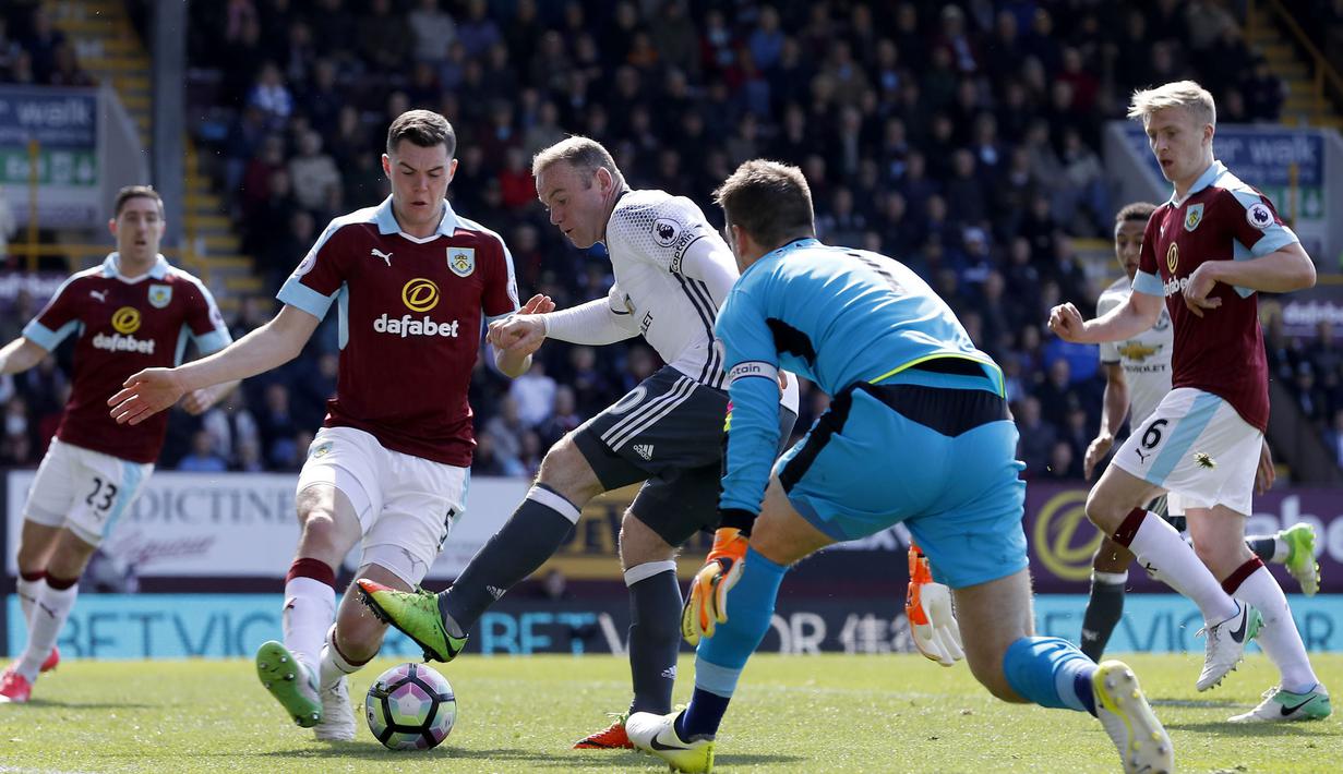 Wayne Rooney berusaha melewati adanangan pemain Burnley  pada lanjutan Premier League di Turf Moor Stadium, Burnley, Minggu (23/4/2017). MU menang 2-0.  (Martin Rickett/PA via AP)