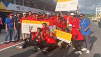 Tim Arjuna dan Nakoela dari Universitas Indonesia saat merayakan kemenangannya dalam Shell Eco-marathon yang dihelat di Sirkuit Mandalika pada Sabtu (15/10/2022). (Liputan6.com/Melinda Indrasari)