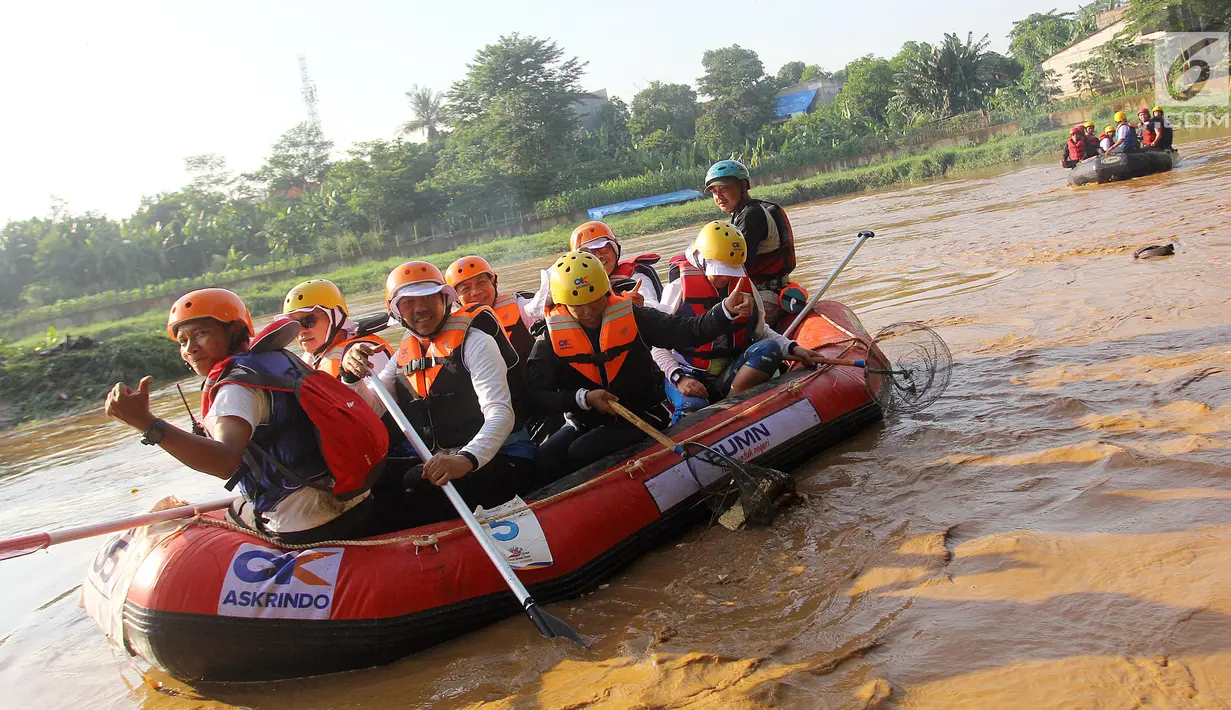 Menteri BUMN Rini M Soemarno membersihkan sampah Sungai Ciliwung dengan naik perahu karet, Jakarta, Minggu (08/4). Rini juga memberikan bantuan 5 perahu karet senilai 120 juta agar masyarakat peduli akan lingkungan sekitar. (Liputan6.com/Fery Pradolo)