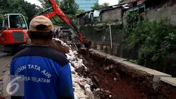 Alat berat dikerahkan untuk mengangkat material yang menutupi saluran air akibat longsor di kawasan Kuningan, Jakarta, Senin (21/11). Curah hujan yang tinggi menjadi penyebab longsor sedalam 17 meter ini. (Liputan6.com/Johan Tallo)