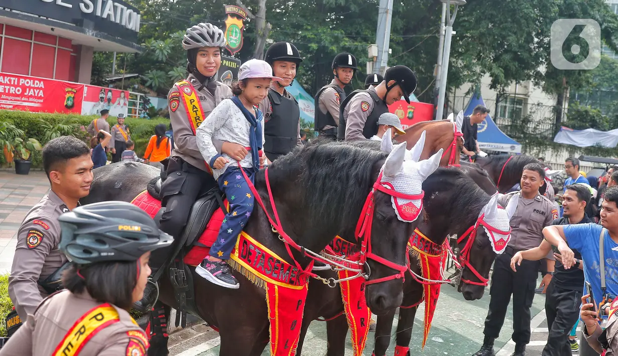 Seorang anak menaiki kuda dari Detasemen Turangga Direktorat Polisi Satwa Polri saat Car Free Day (CFD) atau Hari Bebas Kendaraan Bermotor di kawasan Bundaran HI, Jakarta, Minggu (19/2/2023).Polisi berkuda selain ditugaskan untuk pengamanan simpatik juga untuk menghibur warga dan anak-anak saat Hari Bebas Kendaraan Bermotor serta memperkenalkan profesi tersebut kepada warga. (Lipitan6.com/Angga Yuniar)