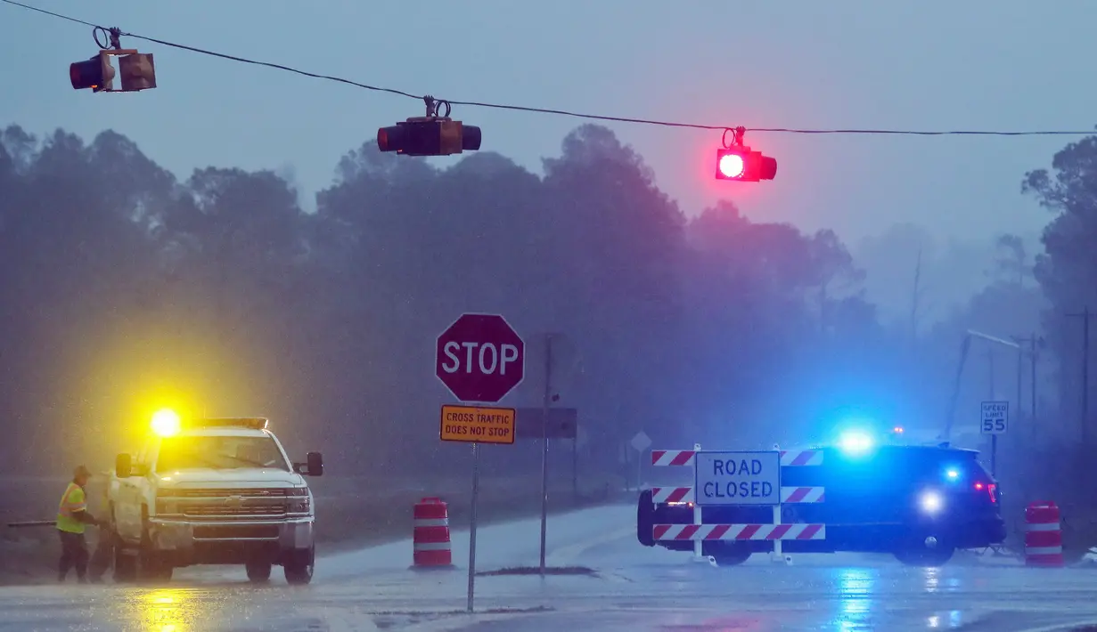 Petugas menutup akses sebuah jalan untuk memperbaiki tiang listrik yang roboh akibat badai besar di Negara Bagian Georgia, Amerika Serikat, Minggu (22/1). Puluhan orang mengalami luka-luka dan sedang dilarikan ke rumah sakit terdekat (AP Photo/Phil Sears)