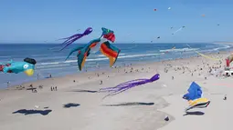 Sejumlah layang-layang berbagai bentuk dan warna memeriahkan Festival Layang-Layang Internasional ke-32 di pantai Berck-sur-Mer, Prancis utara, 18 April 2018. Uniknya, layang-layang terbuat dari kain parasut yang diikat puluhan tali. (Denis Charlet/AFP)