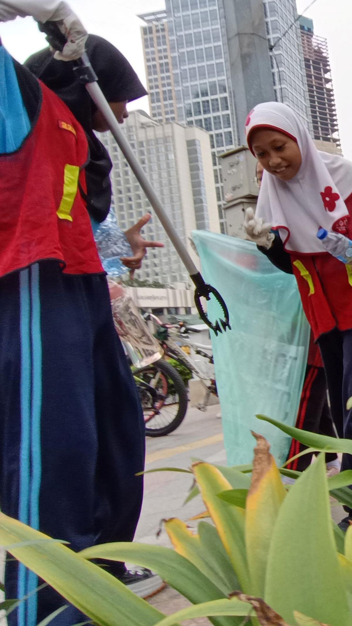 Tak hanya menggunakan tangan, mereka juga memakai alat penyapit sampah saat membersihkan lingkungan di kawasan tersebut. Foto: merdeka.com / Arie Basuki