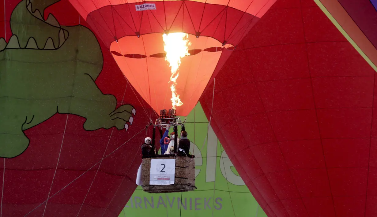 Pasangan pengantin berada di balon udara saat mengikuti Festival Love Cup 2016 di Jekabpils, Latvia (14/2). Sebanyak 50 pasangan pengantin dibagi dalam 27 balon udara terbang bersama mengikat janji cinta mereka. (REUTERS/Ints Kalnins)
