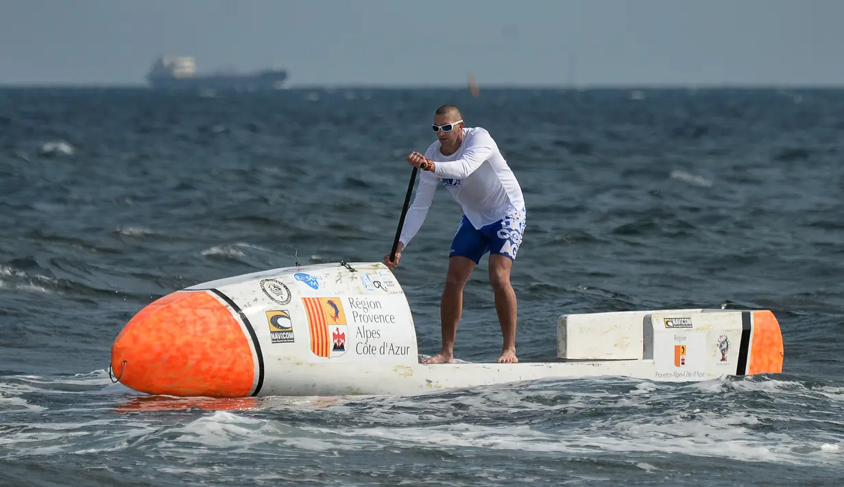 Nicolas Jarossay mendayung papan selancar saat berlatih di perairan lepas Martigues, Perancis, Selasa (15/3). Jarossay berencana memulai aksi dari Tanjung Verde dan mendarat di Karibia. (AFP/BORIS HORVAT)