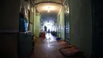Seorang wanita melewati koridor komunal asrama untuk para pekerja pabrik tekstil Proletarka di Kota Tver, Rusia, 8 Agustus 2020. Zaman keemasan Proletarka diakhiri dengan pecahnya Uni Soviet dan datangnya ekonomi pasar yang membuka perbatasan bagi tekstil murah dari China. (Alexander NEMENOV/AFP)