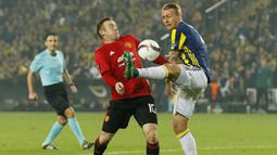 Kapten Manchester United, Wayne Rooney, berebut bola dengan bek Fenerbahce, Simon Kjaer, pada laga Liga Europa di Saracoglu Stadium, Turki, Kamis (3/11/2016). MU kalah 1-2 dari Fenerbahce. (Reuters/Andrew Boyers)