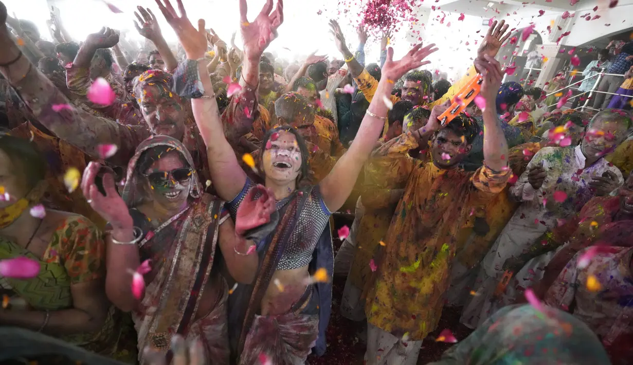 Umat Hindu bersorak saat bubuk berwarna dan air disemprotkan selama perayaan Festival Holi di kuil Kalupur Swaminarayan di Ahmedabad, India (18/3/2022).  Holi, festival warna Hindu, juga menandai datangnya musim semi. (AP Photo/Ajit Solanki)