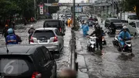 Warga mendorong sepeda motornya saat menerobos banjir di jalan depan Ancol, Jakarta, Kamis (21/4). Hujan deras yang mengguyur sejak semalam menyebabkan beberapa kawasan di Jakarta tergenang banjir. (Liputan6.com/Faizal Fanani)