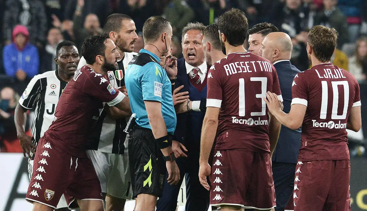 Pelatih Torino, Sinisa Mihajlovic, melakukan protes kepada wasit Paolo Valeri. Pertandingan tersebut berlangsung cukup keras, tercatat 15 pelanggaran dilakukan oleh Juventus dan 11 oleh Torino. (AP/Alessandro Di Marco)
