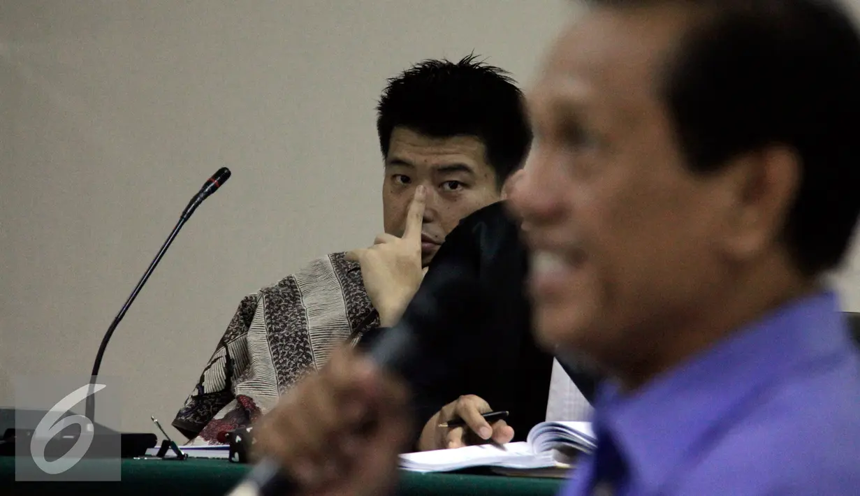 Andrew Hidayat memperhatikan keterangan Mantan Bupati Tanah Laut Adriansyah saat sidang lanjutan di Pengadilan Tipikor, Jakarta, Kamis (30/7/2015). Sidang juga menghadirkan Bupati Tanah Laut Kalsel, Bambang Alamsyah. (Liputan6.com/Yoppy Renato)