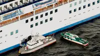 Kapal patroli Japan Coast Guard mengevakuasi penumpang dan kru kapal pesiar Diamond Princess ke rumah sakit di lepas pantai Yokohama, Jepang,  Rabu (5/2/2020). Sebanyak 10 orang di kapal pesiar tersebut dinyatakan positif terinfeksi virus corona. (Hiroko Harima/Kyodo News via AP)