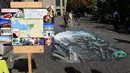 Warga berjalan di dekat karya ilusi optik 3-D yang bergambar kota Aleppo yang hancur akibat perang di kampus Universitas Meiji di Tokyo, Jepang (18/11). (AFP/Toshifumi Kitamura)
