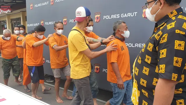 Para penjudi online berikut bandar tengah digiring petugas dalam rilis pengungkapan kasus judi online di Mapolres Garut, Jawa Barat. (Liputan6.com/Jayadi Supriadin)