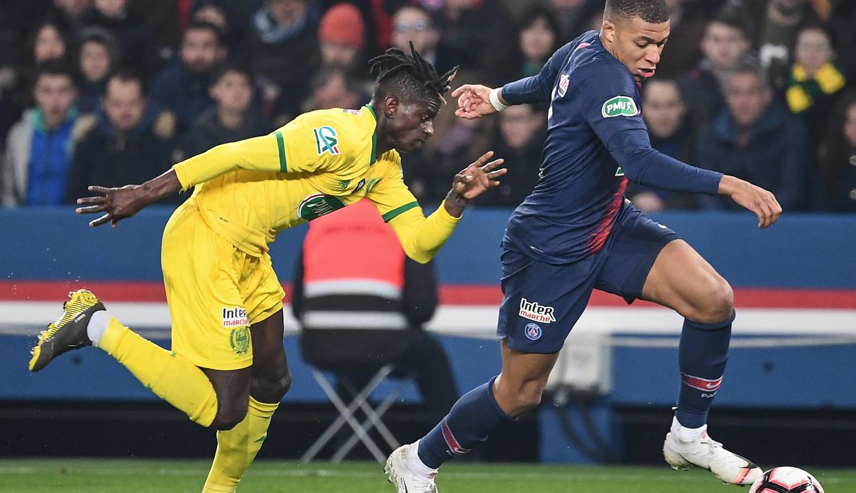 Striker Paris Saint-Germain (PSG), Kylian Mbappe, berebut bola dengan bek FC Nantes, Edgar Le, pada laga semifinal Piala Prancis 2019 di Stadion Parc des Princes, Rabu (3/4). PSG menang 3-0 atas FC Nantes. (AFP/Anne-Christine Poujoulat)