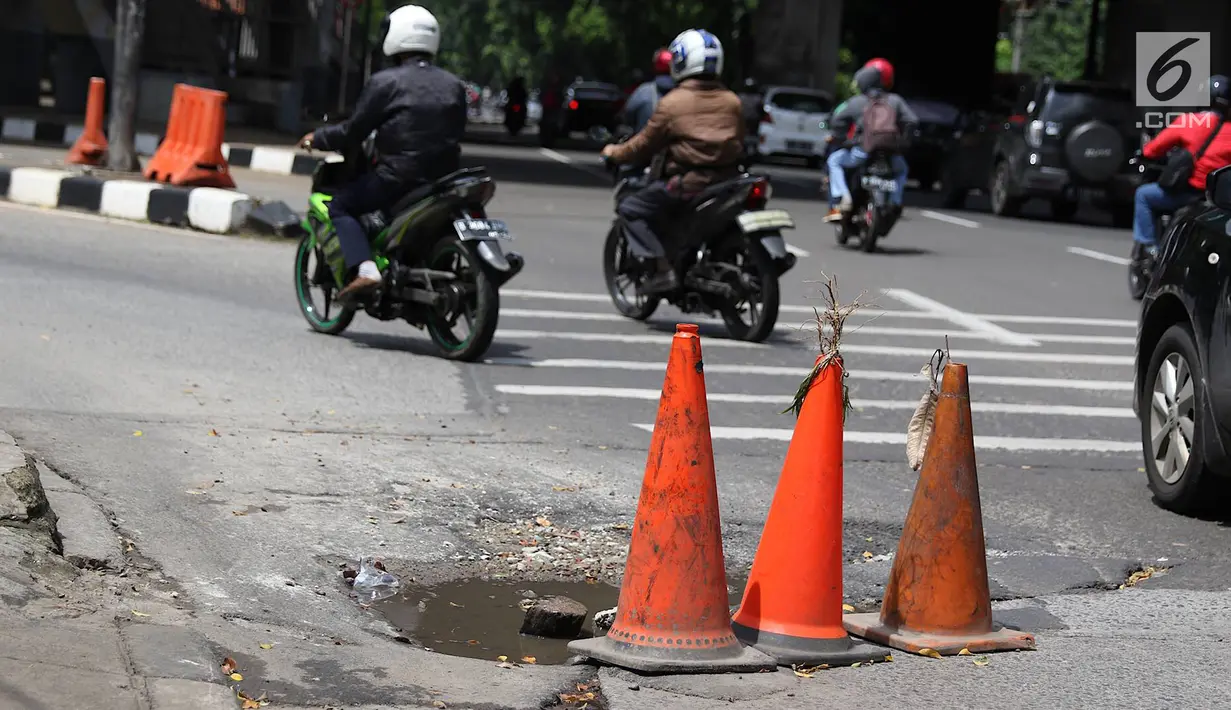 Pengendara menghindari jalan berlubang di kawasan Tanjung Barat, Jakarta, Rabu (30/1). Kondisi jalan rusak tersebut telah beberapa kali menyebabkan kecelakaan sehingga butuh penanganan. (Liputan6.com/Immanuel Antonius)