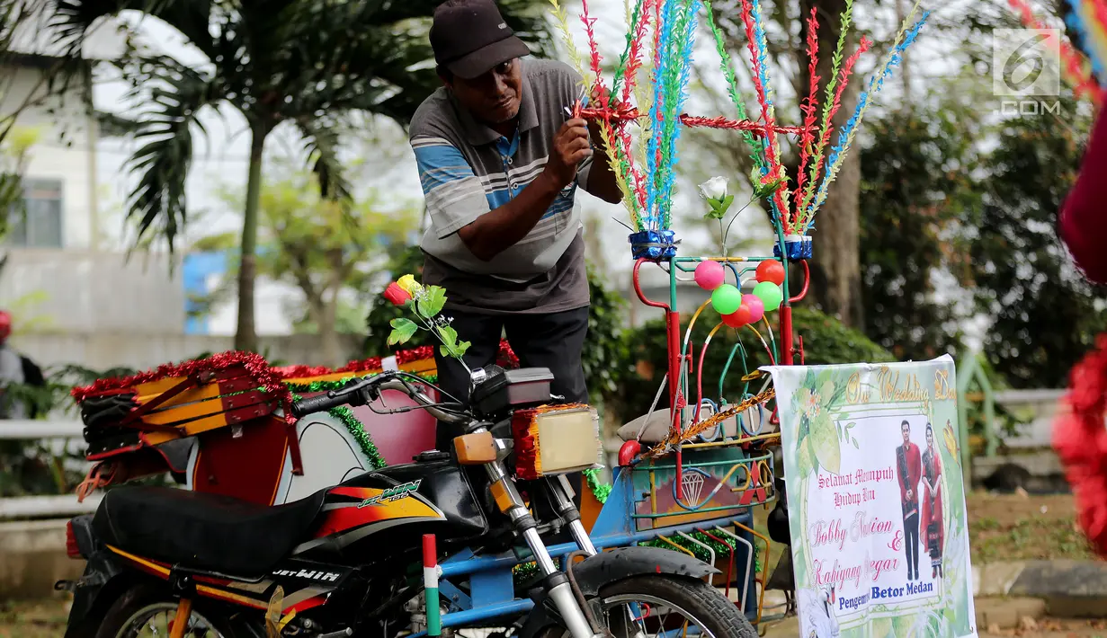Warga sedang menghias Betor (becak motor) di depan kantor Dinas Perhubungan, Medan, Sumatera Utara, Sabtu (25/11). Puluhan betor akan ramaikan kirab budaya ngunduh mantu Kahiyang-Bobby. (Liputan6.com/Endang Mulyana)