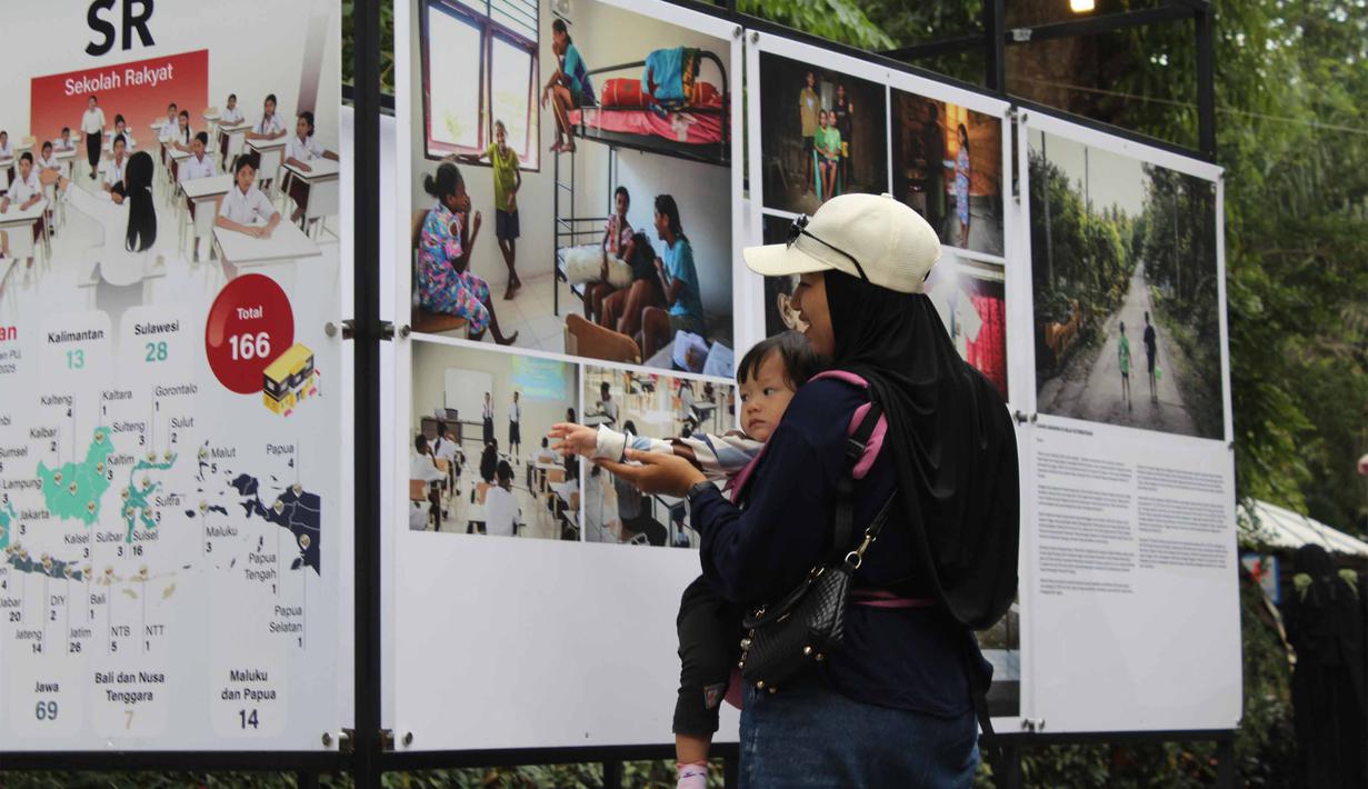 Pameran ini menampilkan kolaborasi karya jurnalistik multiplatform, mulai dari fotografi, pemberitaan teks, video, hingga infografis. Tampak dalam foto, pengunjung menyaksikan karya foto jurnalistik dalam pameran Haluan Merah Putih Roadshow yang digelar di Selasar Kantin Taman Margasatwa Ragunan, Jakarta Selatan, Rabu (24/12/2025). (merdeka.com/magang/Rendi Saputra)