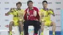 Pebulutangkis ganda putra Indonesia, Marcus Fernaldi Gideon dan Kevin Sanjaya Sukamuljo berpose menunjukkan medali bersama pelatih Aryono Miranat seusai bertanding pada final BWF Dubai Super Series Finals 2017, Minggu (17/12). (instagram/marcusfernaldig)