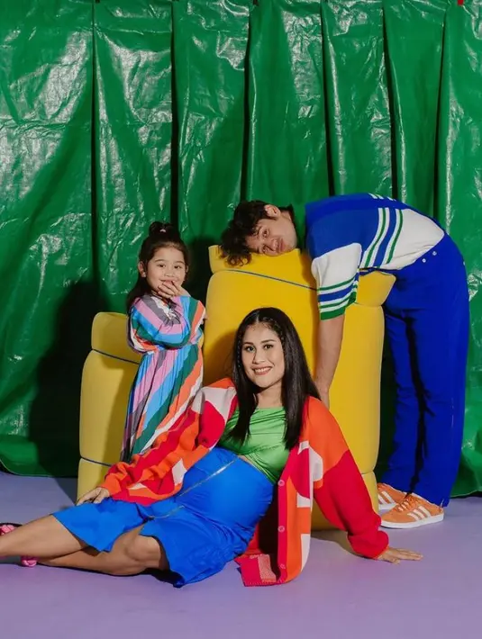 Gya tampil percaya diri menonjolkan baby bump-nya dalam balutan silk top warna hijau, kardigan warna oranye, dan rok warna biru menyala. (Instagram/gyaps).