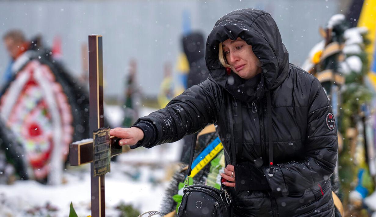 Nataliya menangis di makam saudara laki-lakinya Oleg Kunynets, seorang prajurit militer Ukraina yang terbunuh di bagian timur negara itu, saat pemakamannya di Lviv, Ukraina, 7 Februari 2023. Memasuki hari ke-350 invasi Rusia ke Ukraina, korban jiwa terus berjatuhan di antara kedua belah pihak yang berseteru. (AP Photo/Emilio Morenatti)