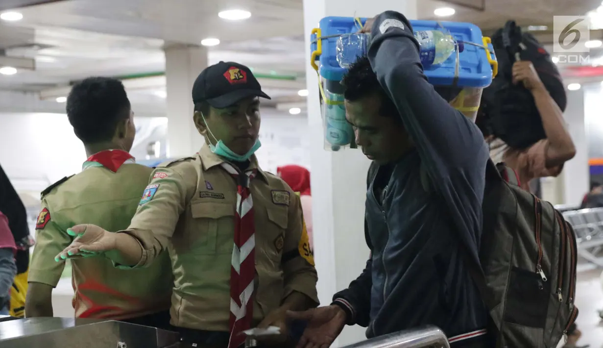 Anggota Pramuka membantu calon penumpang melakukan cek in elektronik di Pelabuhan Penyeberangan Merak, Banten, Sabtu (1/6/2019). Hingga Sabtu (1/6) pukul 08.00 WIB, pemudik yang menyebrang dari pelabuhan Merak menuju Bakauheni mengalami peningkatan 30,1%. (Liputan6.com/Helmi Fithriansyah)
