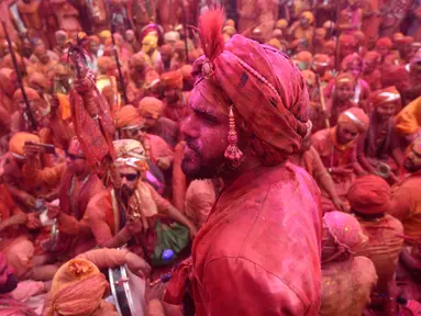 Umat Hindu merayakan Holi, festival warna musim semi, di sebuah kuil di desa Nandgaon, negara bagian Uttar Pradesh, 5 Maret 2020. Ribuan orang India menyambut musim semi pada Kamis (5/3) dengan merayakan Festival Holi yang identik dengan aksi saling melemparkan bubuk warna warni. (Money SHARMA/AFP)