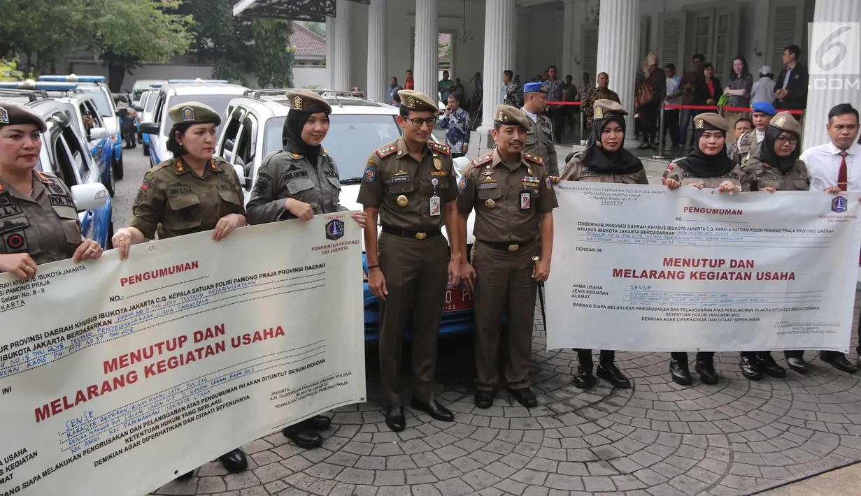 Wakil Gubernur DKI Sandiaga Uno berpose dengan srikandi Satpol PP di halaman Pendopo Balai Kota, Jakarta, Kamis (19/4). Sebanyak 60 srikandi Satpol PP dikerahkan untuk menutup diskotek Exotic dan Sense Karaoke. (Liputan6.com/Arya Manggala)
