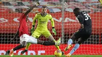 Striker Aston Villa, Keinan Davis (kanan) melepaskan tendangan yang berhasil diblok bek Manchester United, Eric Bailly dalam laga lanjutan Liga Inggris 2020/21 pekan ke-17 di Old Trafford, Jumat (1/1/2021). Aston Villa kalah 1-2 dari Manchester United. (AFP/Carl Recine/Pool)