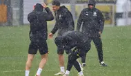 Para pemain Dortmund di sekitar Felix Nmecha (tengah) dikejutkan dengan hujan deras saat sesi latihan di Dortmund, Jerman, Senin (15/4/2024). (Bernd Thissen/dpa via AP)