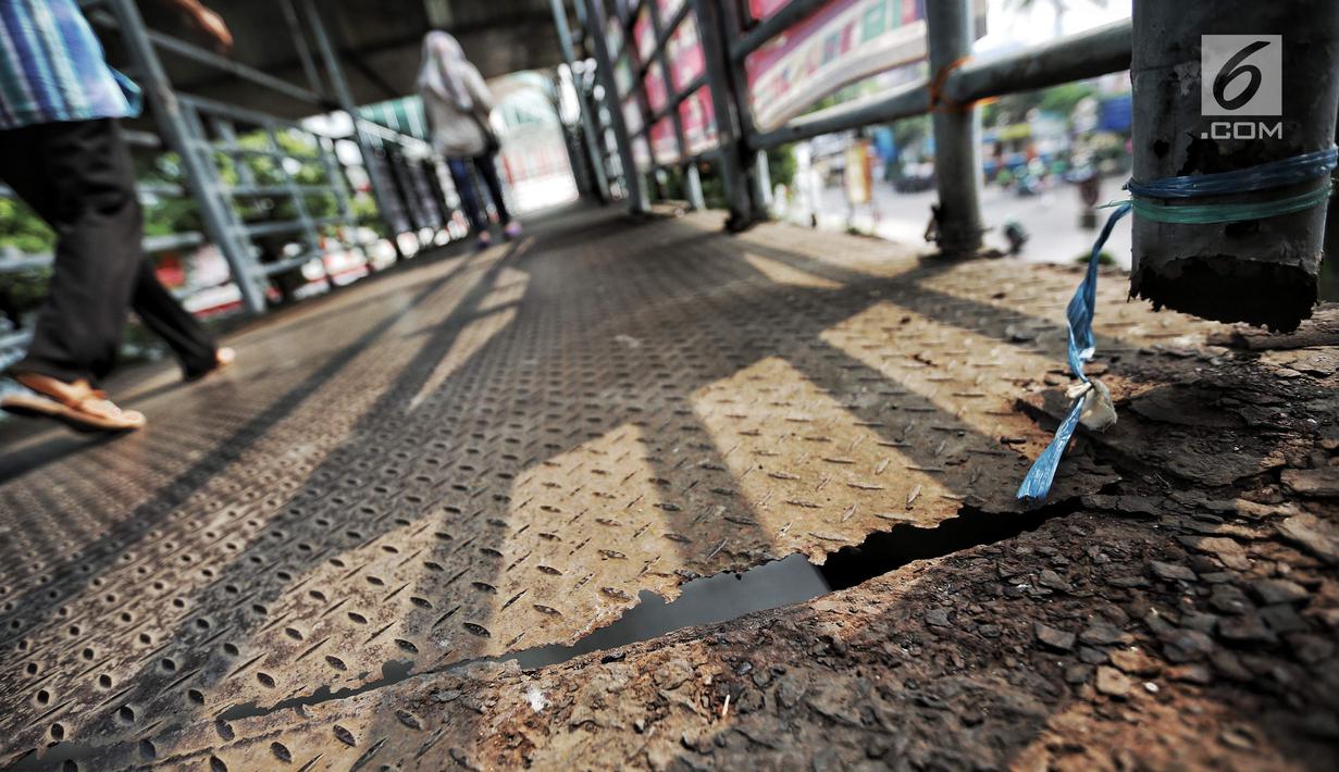 Lantai Jembatan penyeberangan orang (JPO) di Jalan Iskandarsyah Raya, Blok M, Jakarta yang berlubang, Kamis (23/8). Warga mengeluhkan kondisi JPO Blok M yang sangat mengkhawatirkan. (Liputan6.com/Faizal Fanani)