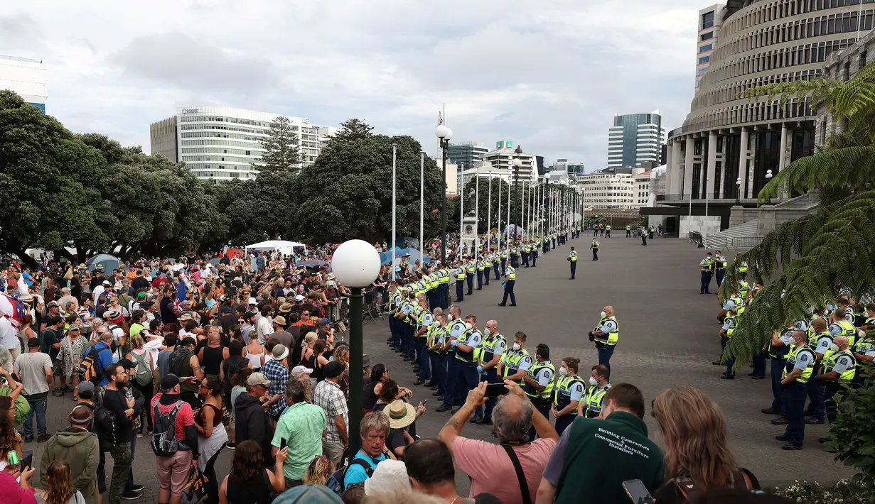 Polisi mundur dari barisan dan mundur ke depan gedung Parlemen pada hari ketiga demonstrasi menentang pembatasan Covid-19, terinspirasi oleh demonstrasi serupa di Kanada, di Wellington (10/2/2022). (AFP/Marty Melville)