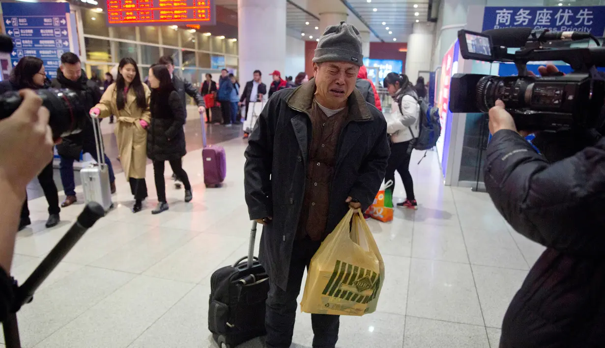 Wen Wanchang menangis saat tiba di stasiun kereta api di Beijing, China (18/1). Kelompok pendukung keluarga MH370, mengatakan pencarian harus terus dilakukan dan diperluas ke arah utara dari tempat pencarian saat ini. (AP Photo/Ng Han Guan)