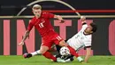 Pemain Jerman Mats Hummels (kanan) berebut bola dengan pemain Denmark Daniel Wass (kiri) pada pertandingan persahabatan di Tivoli Stadion Tirol, Innsbruck, Austria, Rabu (2/6/2021). Pertandingan berakhir dengan skor 1-1. (Frederico Gambarini/Pool via AP)