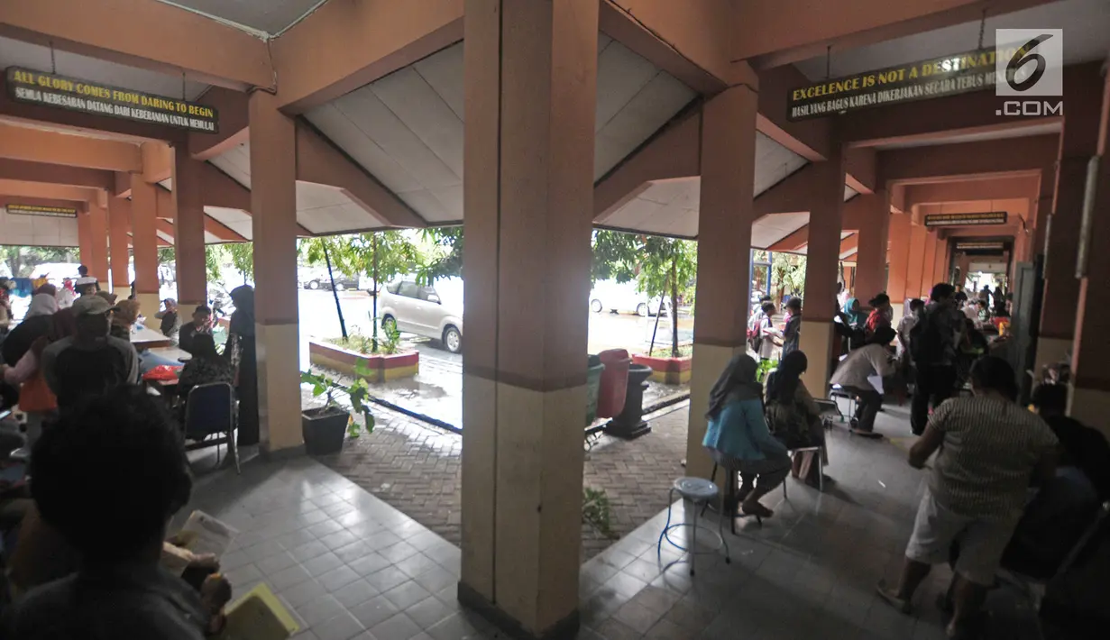 Sejumlah calon siswa baru saat menunggu antrean pengambilan nomor token PPDB di SMPN 92, Jakarta, Senin (25/6). Para orang tua calon siswa baru sudah mendatangi sekolah sejak pukul 6 pagi. (Merdeka.com/Iqbal S Nugroho)