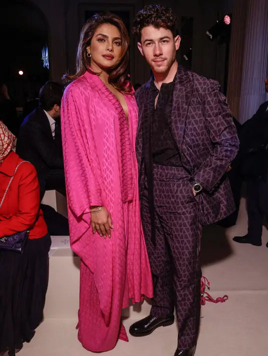<p>Priyanka Chopra (kiri) dan Nick Jonas menghadiri koleksi siap pakai Valentino Fall/Winter 2023-2024 yang dipresentasikan di Paris Fashion Week, Paris, Prancis, 5 Maret 2023. Chopra yang tampil serba pink membiarkan rambut cokelatnya tergerai, sementara untuk riasan dia memakai lipstik merah dan mata smokey. (Vianney Le Caer/Invision/AP)</p>