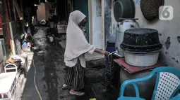 Warga menggunakan air tampungan di Kampung Baru Kubur, Penjaringan, Jakarta Utara, Selasa (11/1/2022). Warga mengaku krisis air bersih terjadi pada pagi dan sore hari, baik pengguna air ledeng atau tanah maupun Palyja. (merdeka.com/Iqbal S. Nugroho)