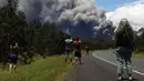 Sejumlah orang menonton dan mengambil gambar kepulan abu vulkanik dari gunung berapi Kilauea di Big Island Hawaii (15/5). Otoritas Hawaii menyatakan, awan abu mencapai ketinggian sekitar 3.000 meter hingga 3.600 meter. (Mario Tama/Getty Images/AFP)