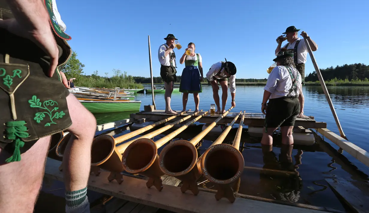Musisi alphorn, Holdersberger Alp-Traum-Bläser minum bir sabelum tampil di di danau Elbsee, Jerman selatan (11/6). Alphorn ini merupakan alat musik tradisional yang berasal dari Pegunungan Alpen. (AFP PHOTO / DPA / Karl-Josef Hildenbrand / Germany Out)