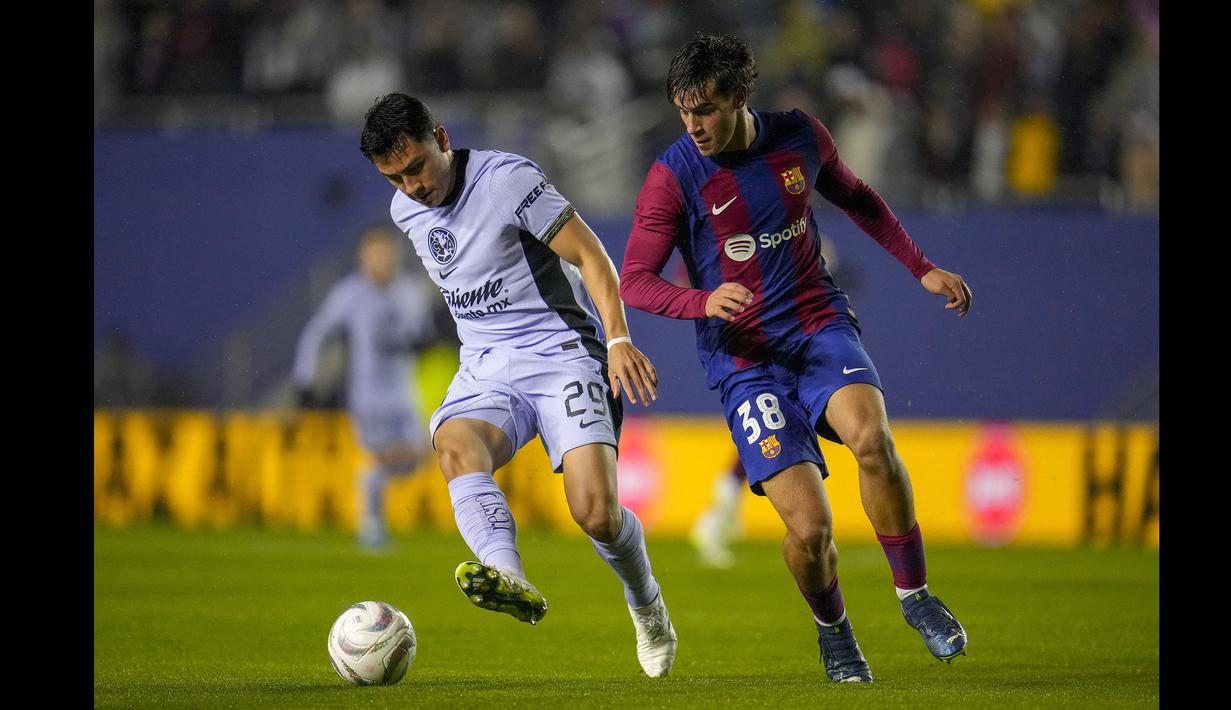Pemain Barcelona, Marc Guiu (kanan) berusaha merebut bola dari kaki pemain Club America, Ramon Juarez pada laga persahabatan di Cotton Bowl, Dallas, Amerika Serikat, Jumat (22/12/2023) dini hari WIB. (AP Photo/Julio Cortez)