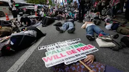 Warga yang menyatakan solidaritas terhadap Palestina berbaring di jalan saat mengikuti aksi yang mengecam tindakan militer Amerika Serikat dan Israel di Gaza, di Seoul, Korea Selatan, Sabtu (3/10/2026). Aksi tersebut menjadi bagian dari unjuk rasa solidaritas terhadap Palestina yang digelar di pusat kota Seoul. Para peserta melakukan aksi die-in dengan berbaring di jalan sebagai simbol korban konflik di Gaza. Unjuk rasa berlangsung di tengah seruan peserta agar konflik di Gaza dihentikan. (AP Photo/Ahn Young-joon)