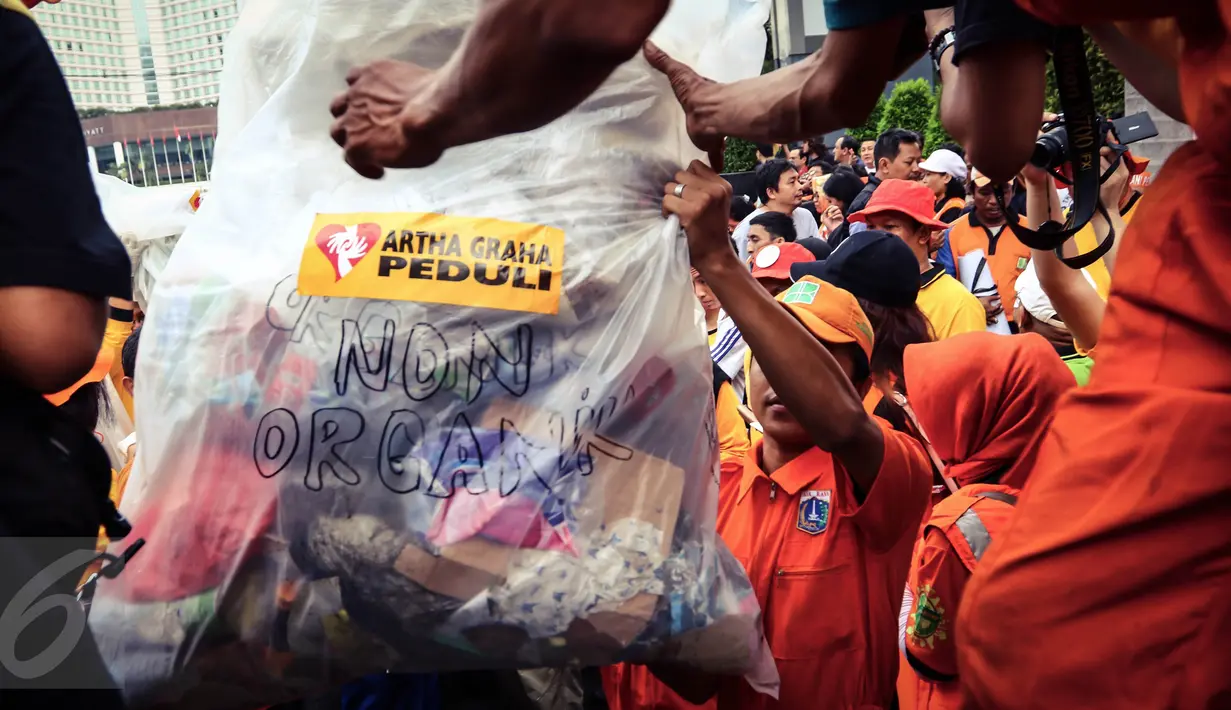 Karyawan dan relawan Artha Graha Peduli mengangkut kantong sampah untuk ditimbang di kawasan Bundaran HI, Jakarta, (21/02). (Liputan6.com/Fery Pradolo)