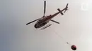 Helikopter water bombing Badan Nasional Penanggulangan Bencana (BNPB) melakukan pemadaman di Tempat Pembuangan Akhir (TPA) Rawa Kucing, Neglasari, Kota Tangerang, Banten, Senin (23/10/2023). Hingga hari keempat, proses pemadaman api terus dilakukan. (merdeka.com/Arie Basuki)