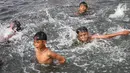 Anak-anak berenang di Kanal Banjir Barat (KBB) yang hitam di Petamburan, Jakarta, Senin (12/8/2019). Anak-anak memanfaatkan waktu pulang sekolah mereka untuk berenang dan mencari ikan di KBB saat musim kemarau. (Liputan6.com/Fery Pradolo)