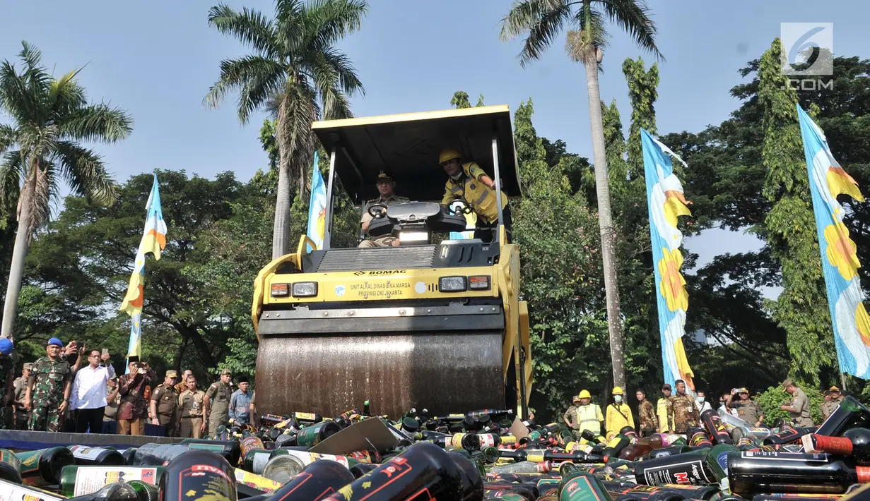 Gubernur DKI Jakarta, Anies Baswedan menggiling ribuan botol minuman keras (miras) ilegal dengan alat berat di Lapangan Silang Monas Tenggara, Senin (27/5/2019). Pemprov DKI memusnahkan 18.174 botol miras tanpa izin hasil penertiban periode Januari 2019 hingga Mei 2019. (merdeka.com/Iqbal S Nugroho)