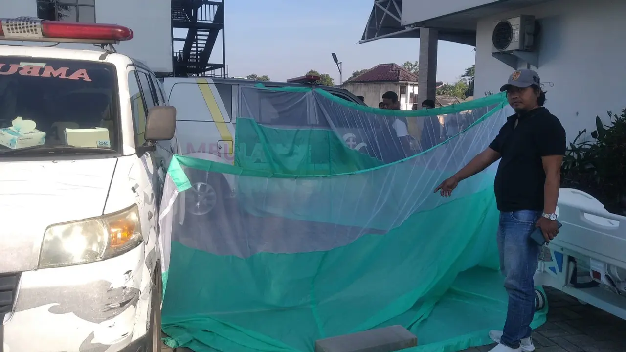 Salah seorang personel kepolisian menunjuk titik lokasi pasien rumah sakit lompat dari lantai tujuh. (Liputan6.com/Dicky Agung Prihanto)
