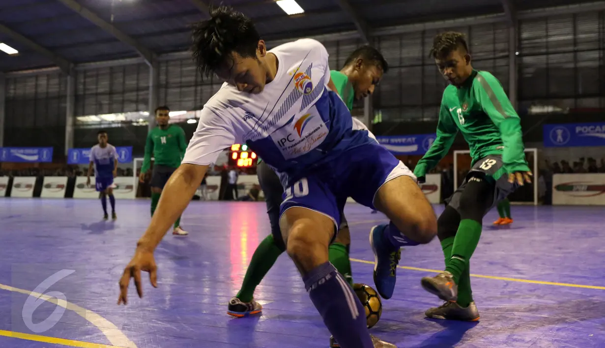 Pemain IPC Pelindo mencoba melewati kawalan dua pemain Timnas Futsal Indonesia saat laga uji coba di Jakarta, Minggu (15/1). Timnas Futsal Indonesia akan melakoni laga piala AFF 2017, akhir Januari. (Liputan6.com/Helmi Fithriansyah)