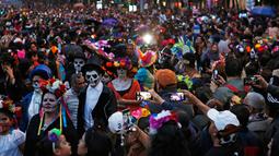 Suasana saat peserta yang berdandan ala tengkorak saat mengikuti parade Hari Orang Mati di Mexico City, Meksiko, Sabtu (26/10/2019. Para peserta dalam parade ini mengenakan kostum dan melukis wajah mirip dengan tokoh tengkorak Meksiko yang ikonik, Catrina. (AP Photo/Ginnette Riquelme)